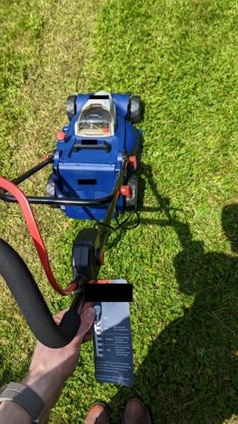 A person holding a lawnmower

AI-generated content may be incorrect.