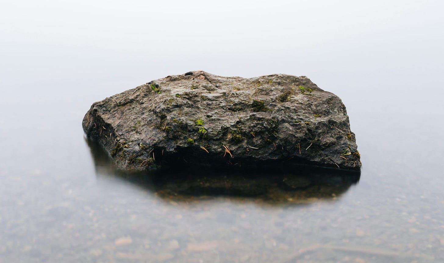 brown stone in body of calm water