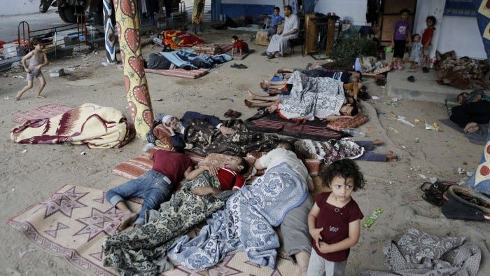 Displaced Palestinians sleep on the ground on July 23, 2014 at a UN school in the refugee camp of Jabalia where families fleeing heavy fighting in the besieged Palestinian territory have taken refuge. A United Nations school sheltering displaced Palestinians in central Gaza came under Israeli fire on July 22 as a team was inspecting damage from a day earlier, a UN official said. UNRWA is sheltering more than 100,000 people at more than 60 of its schools throughout the Gaza Strip. AFP PHOTO / MOHAMMED ABEDMOHAMMED ABED/AFP/Getty Images