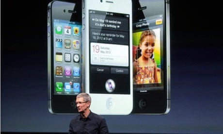 Apple CEO Tim Cook speaks in front of an image of an iPhone 4S at Apple headquarters in Cupertino