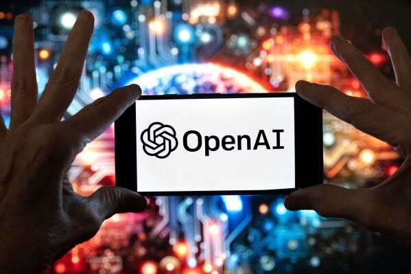 The OpenAI logo is seen displayed on a cell phone in front of an image on a computer screen generated by ChatGPT's Dall-E text-to-image model, Friday, Dec. 8, 2023, in Boston. (AP Photo/Michael Dwyer, file) The OpenAI logo is seen displayed on a cell phone in front of an image on a computer screen generated by ChatGPT's Dall-E text-to-image model, Friday, Dec. 8, 2023, in Boston. (AP Photo/Michael Dwyer, file)