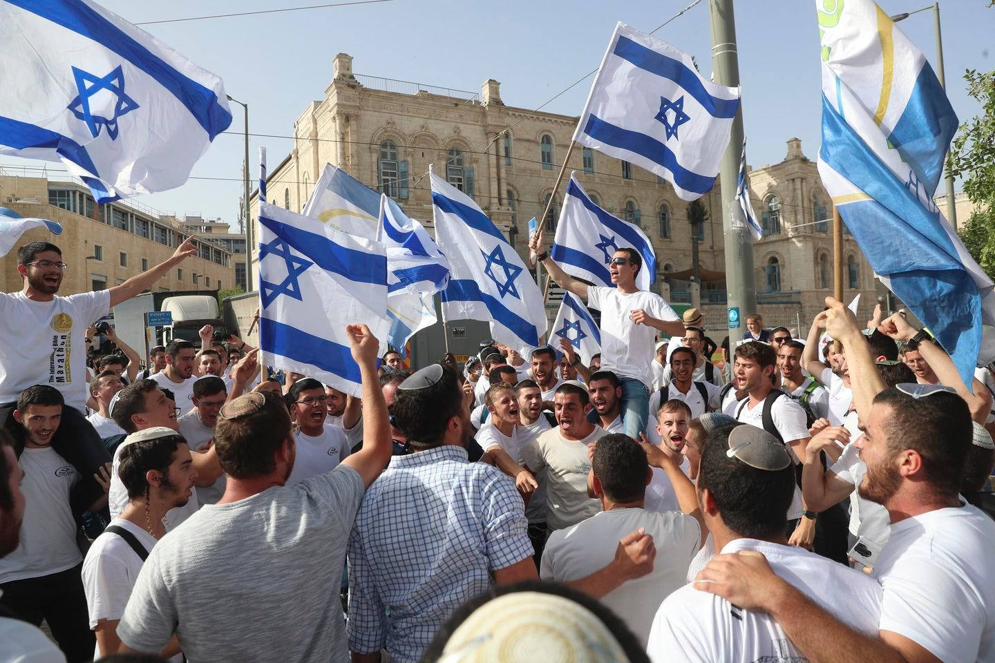 In this May 10, 2021, file photo, Israelis waved national flags during a Jerusalem Day parade, in Jerusalem. Israel’s new government on Monday approved a contentious parade by Israeli nationalists through Palestinian areas around Jerusalem's Old City, setting the stage for possible renewed confrontations just weeks after an 11-day war with Hamas militants in the Gaza Strip.