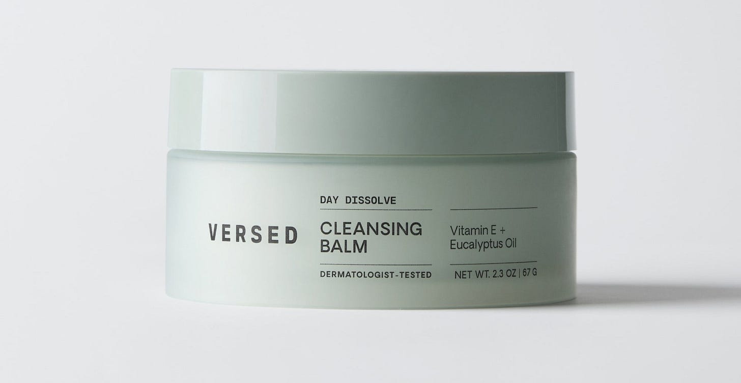 Versed Day Dissolve cleansing balm in a pale green jar with white lid, labeled with Vitamin E and Eucalyptus Oil ingredients. Versed Day Dissolve cleansing balm in a pale green jar with white lid, labeled with Vitamin E and Eucalyptus Oil ingredients.