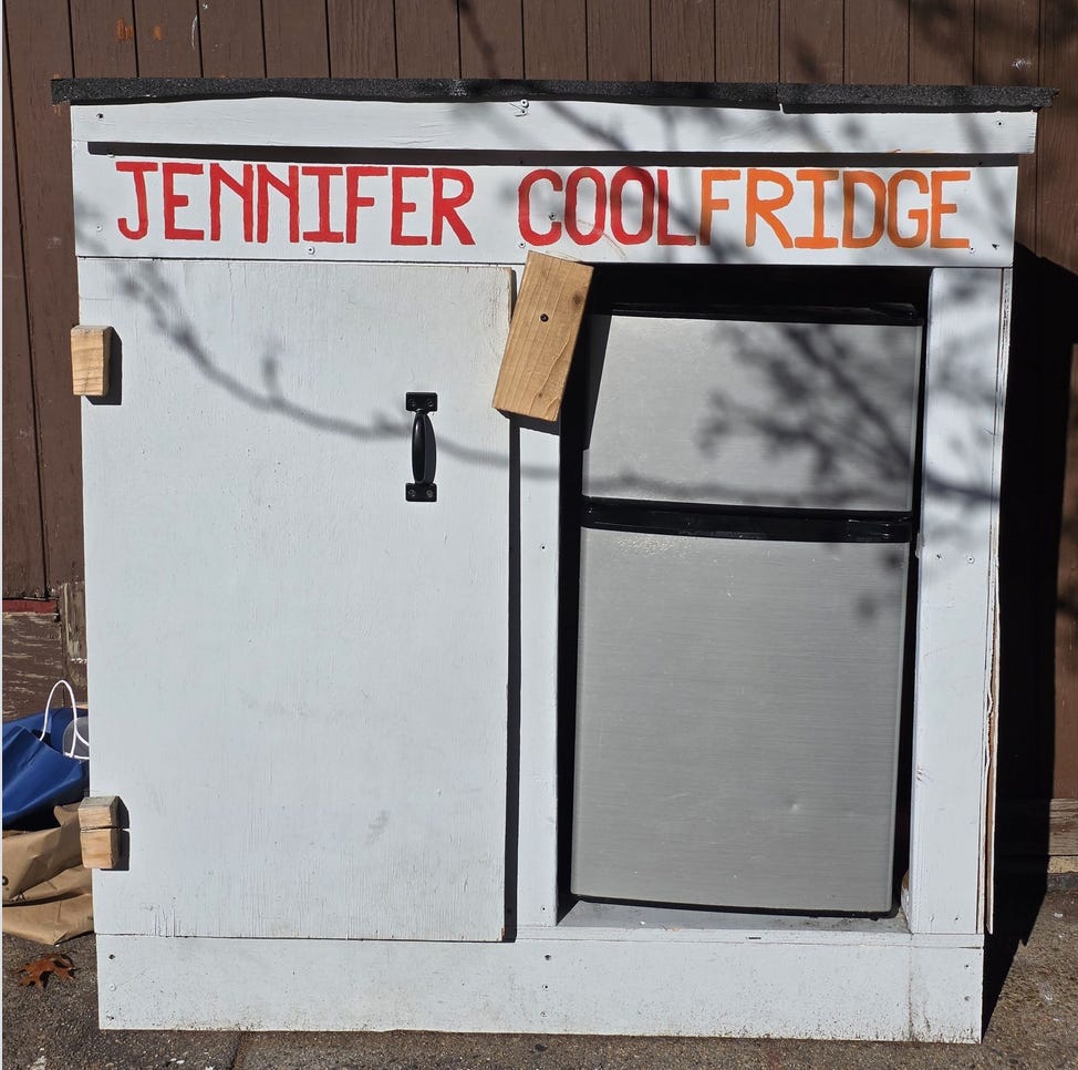 A white refrigerator with JENNIFER COOLFRIDGE written on it in large red block letters A white refrigerator with JENNIFER COOLFRIDGE written on it in large red block letters