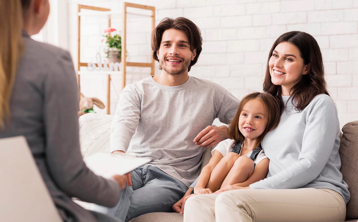 A mother, father, and daughter talking to a counselor