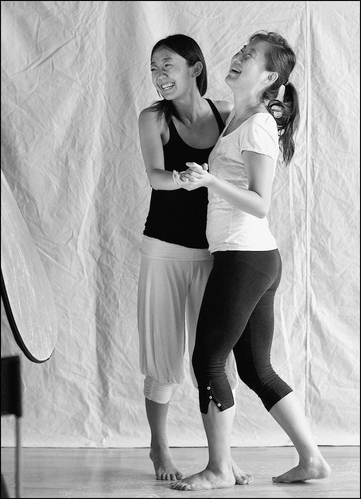 Two girls laughing and dancing