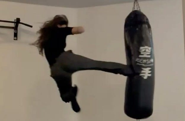 This may contain: a person jumping in the air with a punching bag