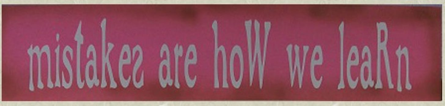 Pink sign with white letters saying "mistakes are how we learn." There are several errors in the writing of the sign-backwards letters and  errors in capitalization.