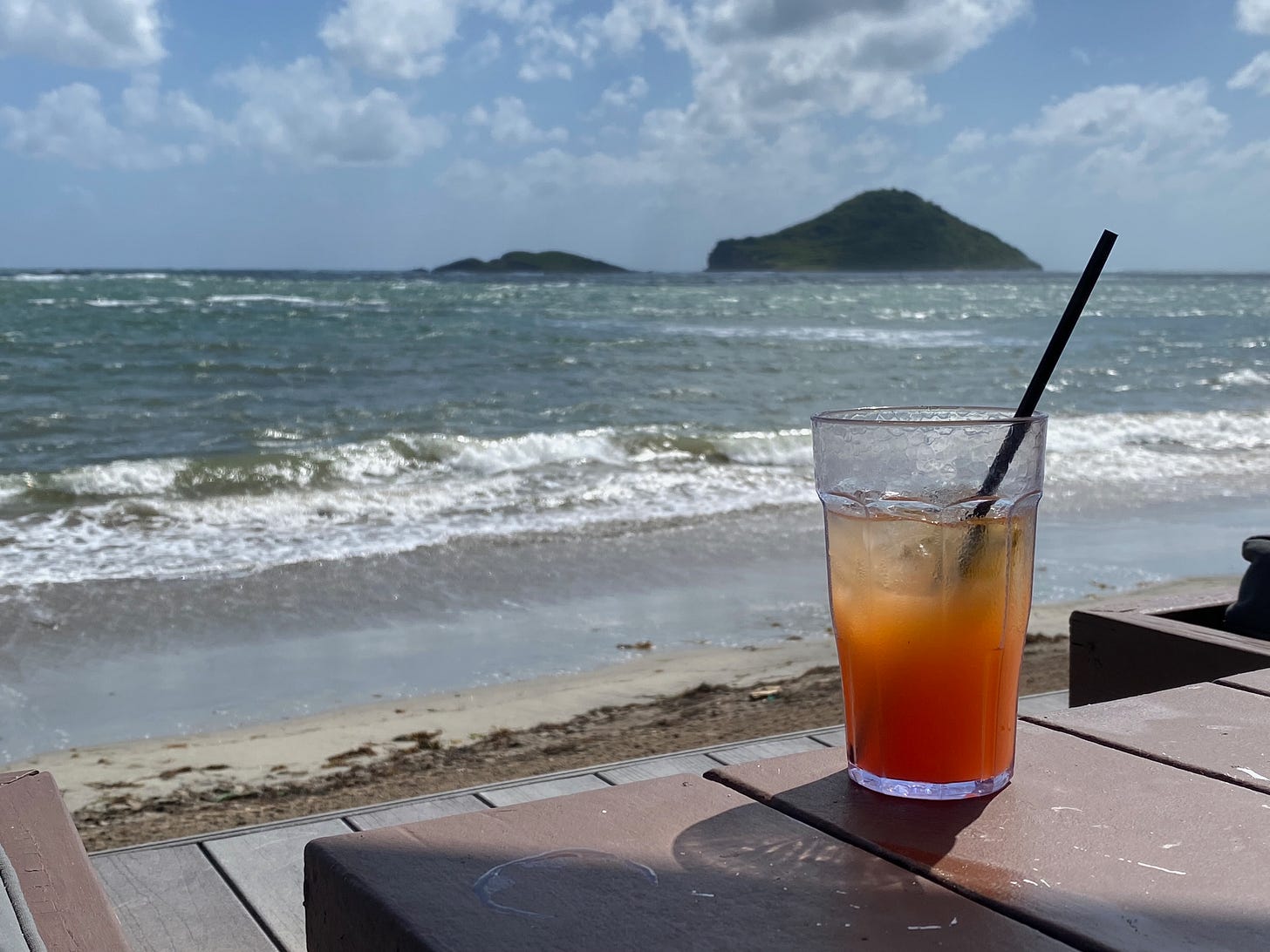 Tropical drink with St. Lucia beach in the background.