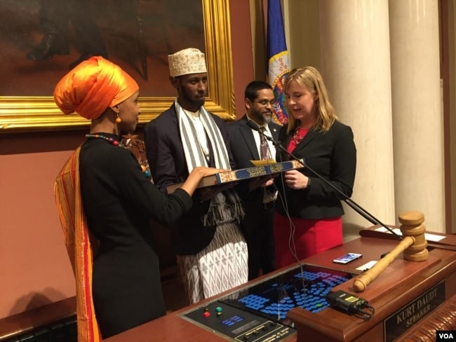 Ilhan Omar takes the Oath of Office on a special Koran in a ceremony at the Minnesota State Capitol Building, Jan. 3, 2017. (K. Farabaugh/VOA)