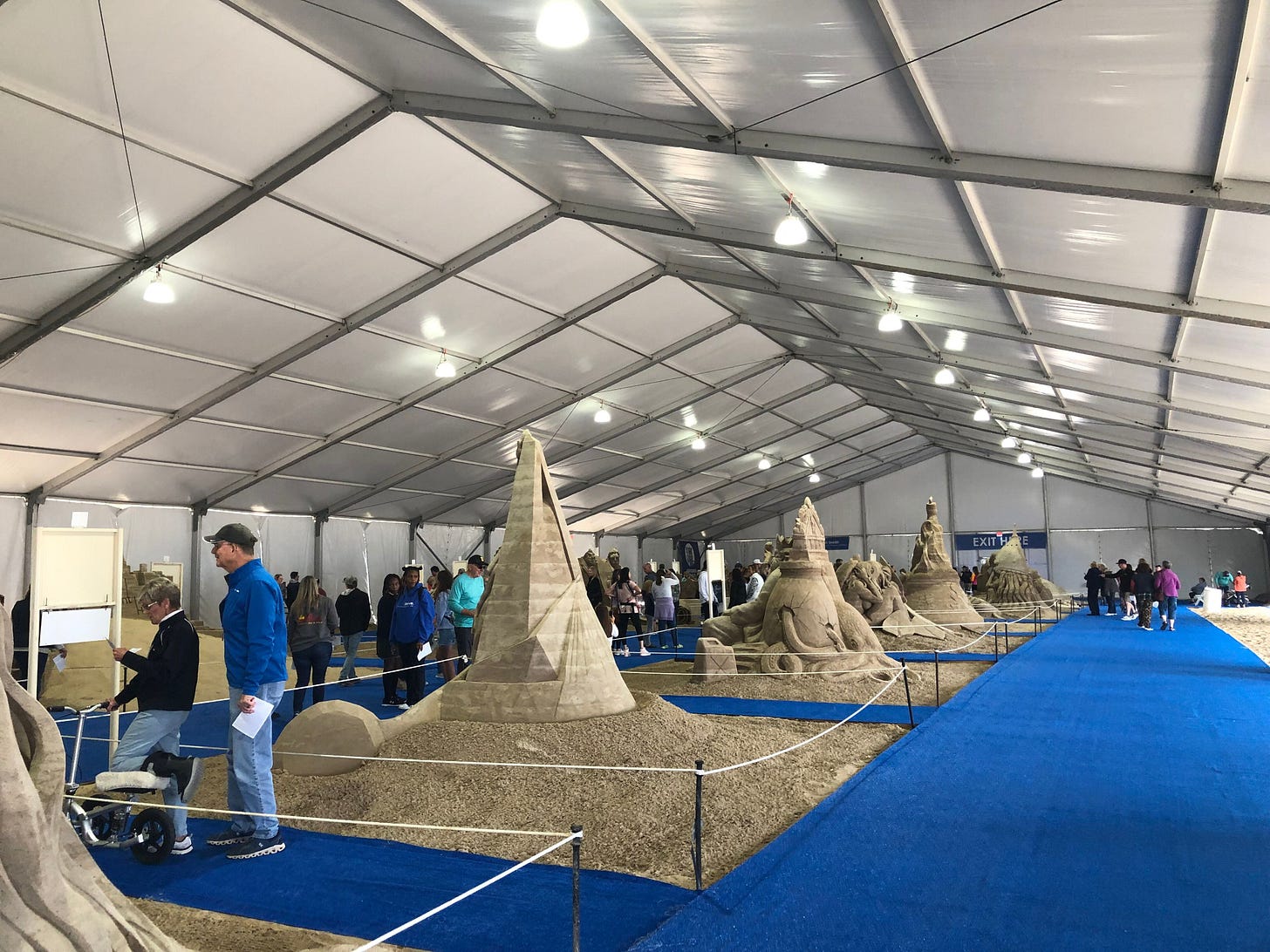 inside the sand sculpting tent where sculptures are lined in rows