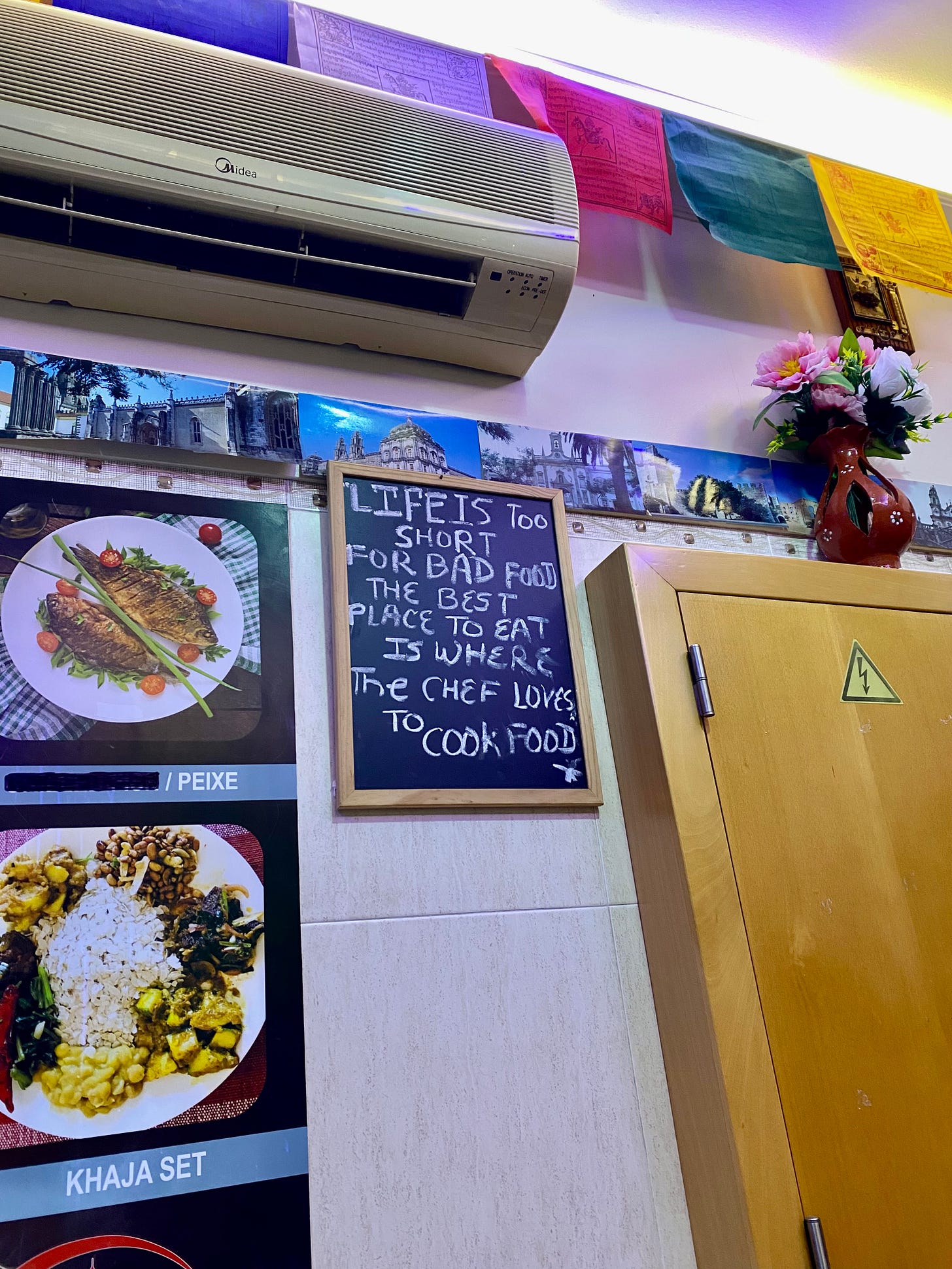 A restaurant wall with photos and a chalk board