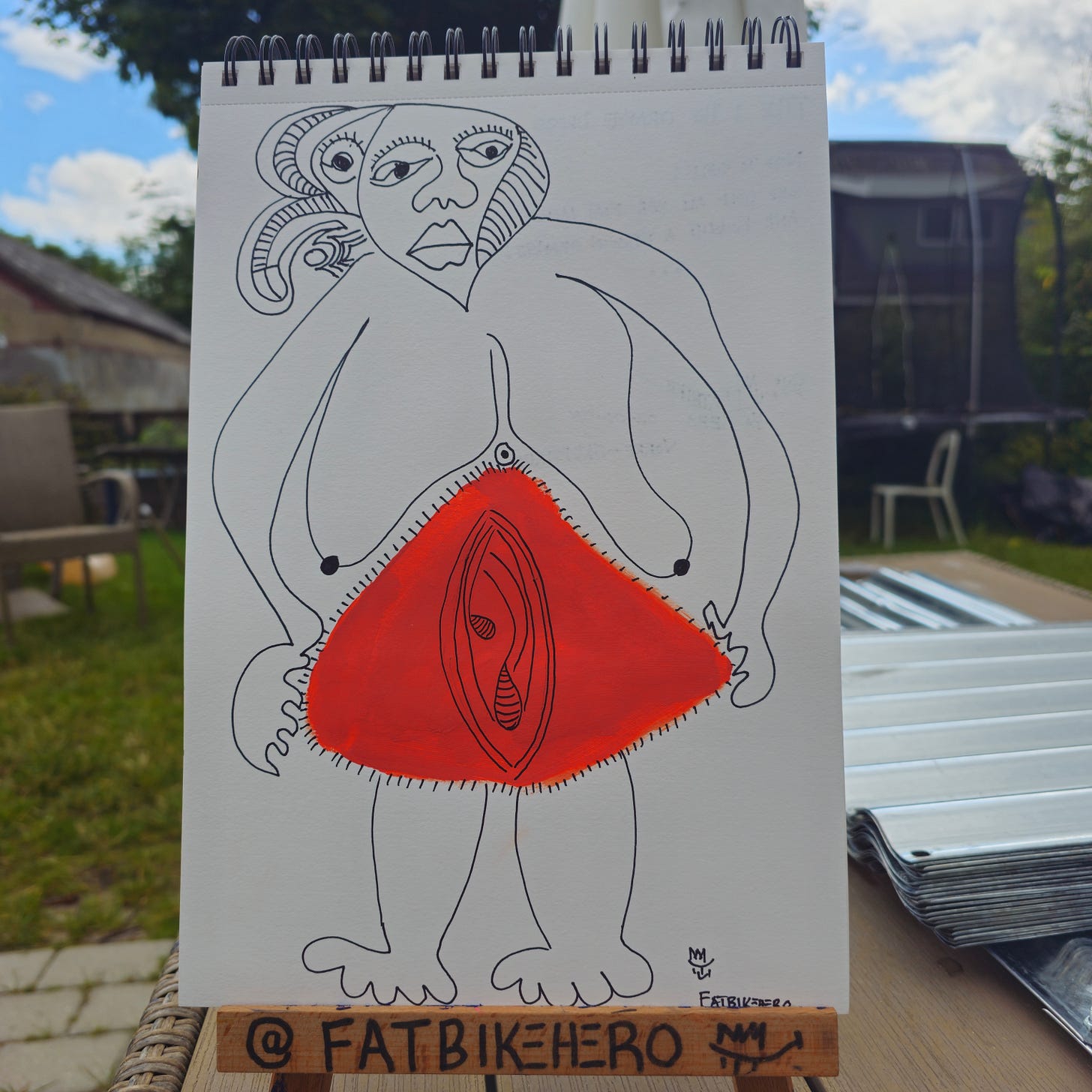 Alt Text: A hand-drawn ink and orange paint illustration on white paper by FatbikeHero titled "The Orange Dress." The figure is a stylized woman with a multi-featured head and large, claw-like hands. A large, vibrant orange triangle dominates the center of the figure, containing a detailed, eye-like central motif.