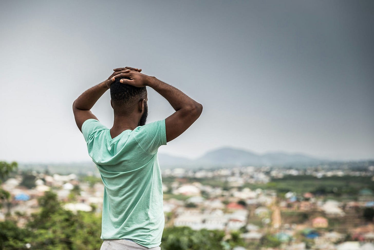 A Nigeria man staring out over his city. 
