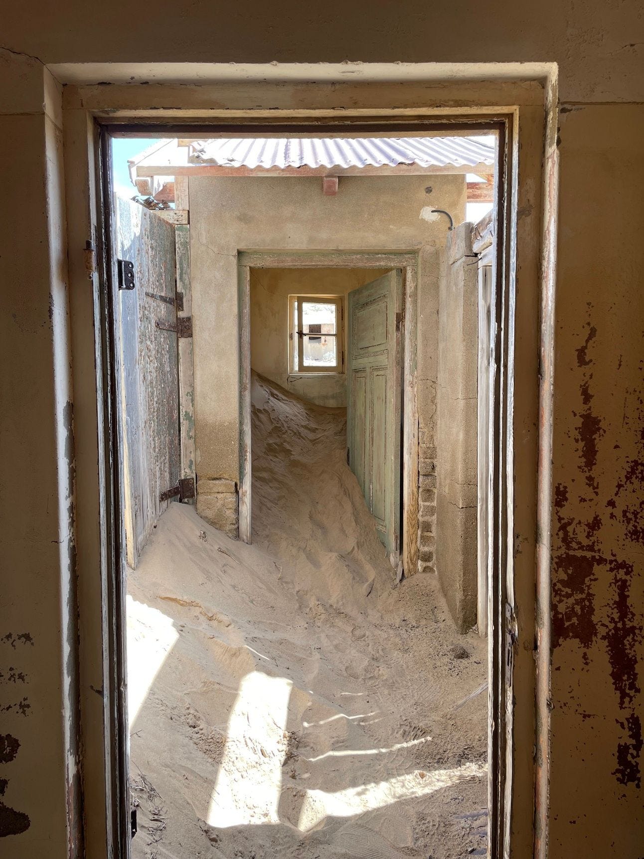 open doorways showing sand blown into an abandoned house