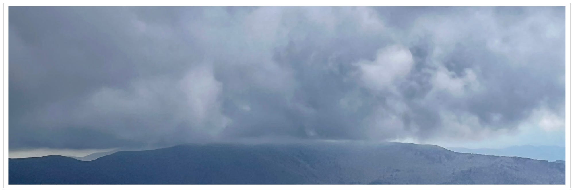 heavy cloud over mountain ridge, barely a distinction between them