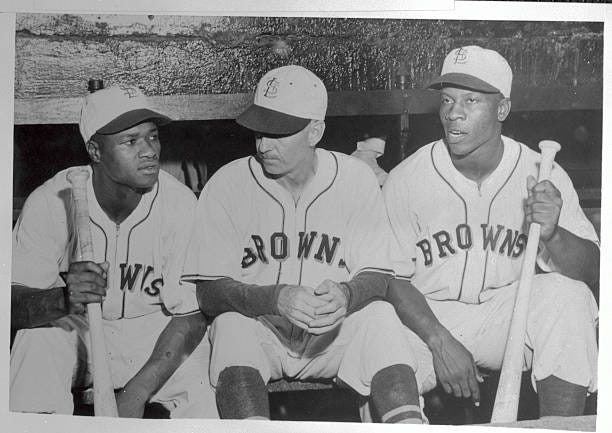 Two Negro players who signed with the St.Louis Browns of the American League sit in the dugout with the manager "Muddy" Ruel prior to the July 17th... Two Negro players who signed with the St.Louis Browns of the American League sit in the dugout with the manager "Muddy" Ruel prior to the July 17th...