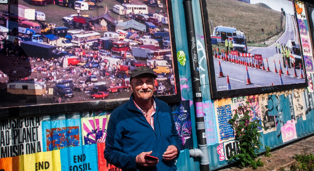 A man - Alan Lodge - stood in front of a billboard of pictures