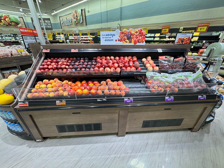 peach displays at a farmstand and the grocery store