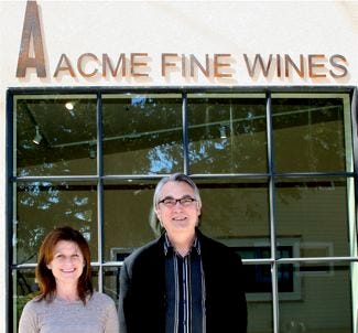Acme – Karen and David in front of sign outside Acme – Karen and David in front of sign outside
