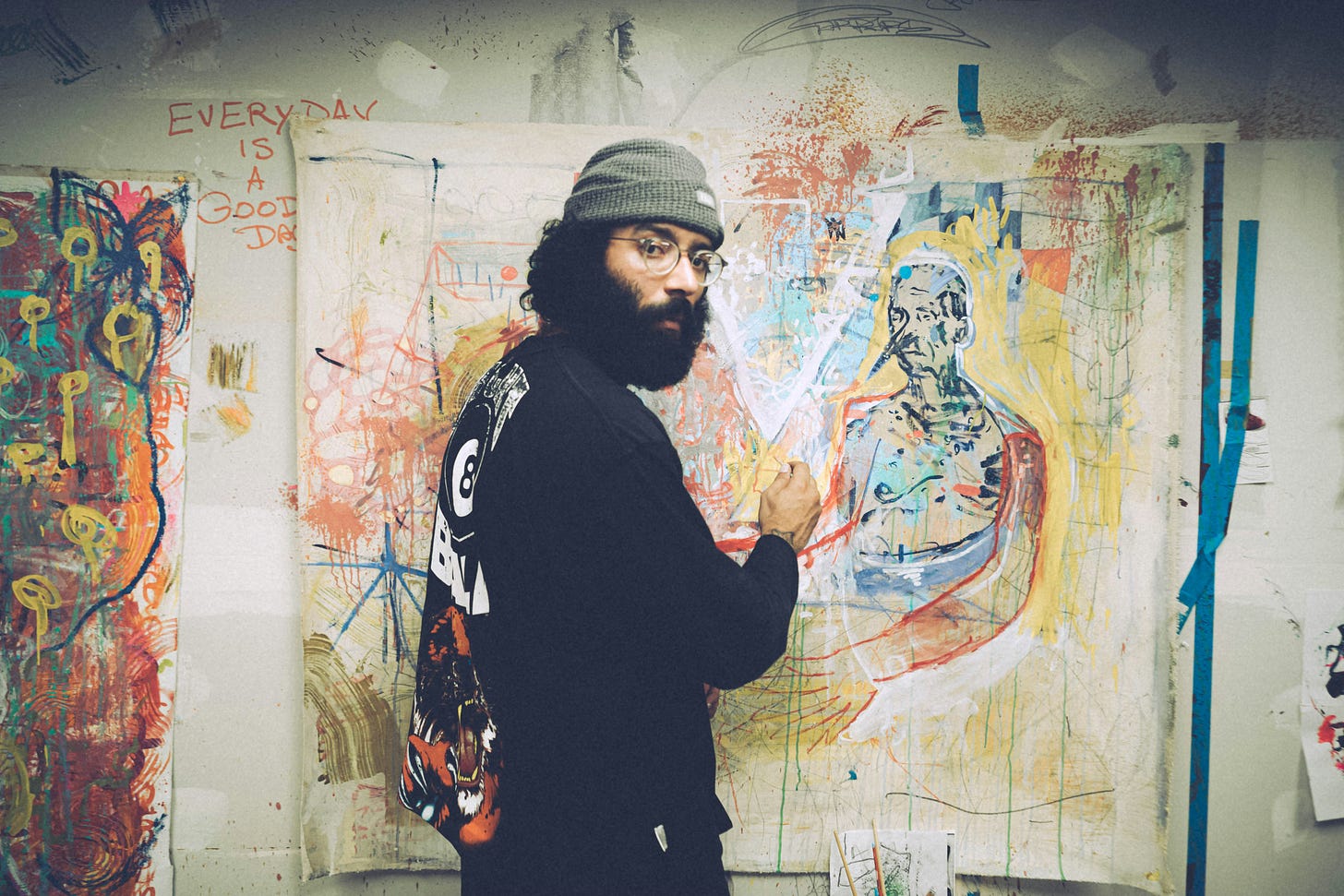 A man with a beard painting cool art.