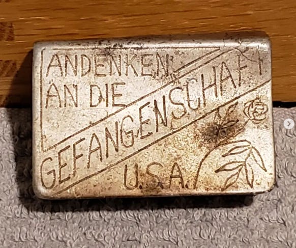 Metal matchbook case hand engraved with the words “memories of captivity” in German.