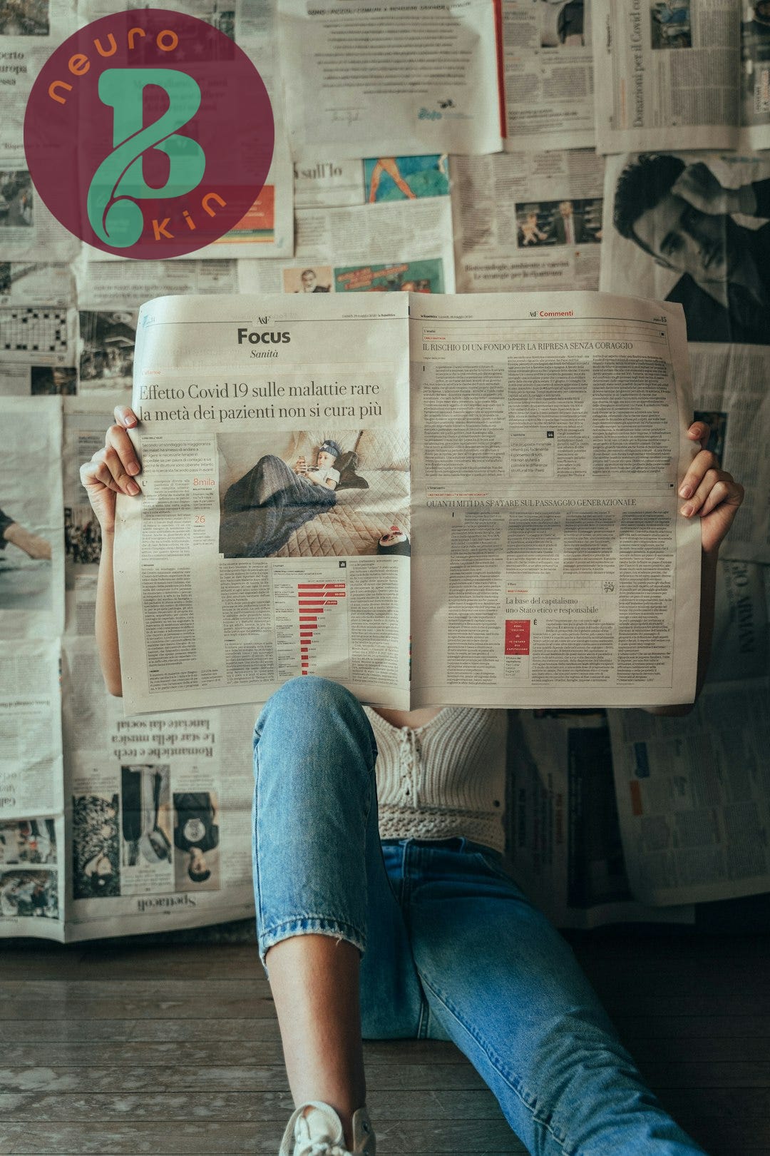 person in blue denim jeans holding white magazine