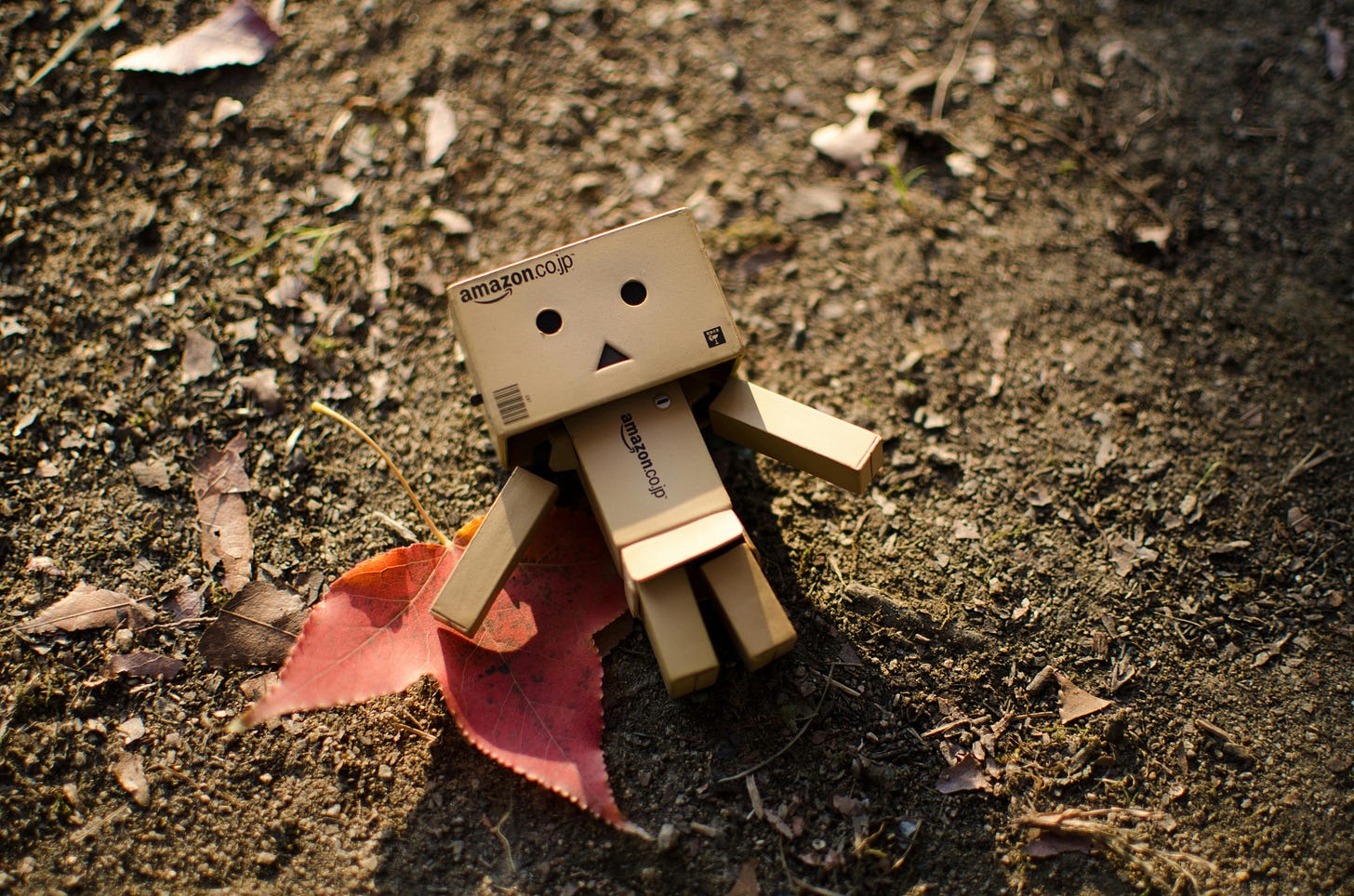 A robot made of cardboard on the ground.
