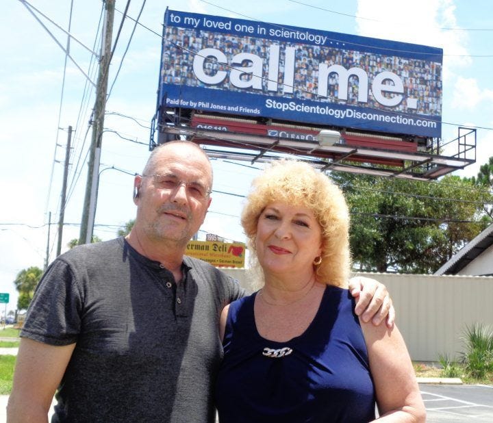 This may contain: a man and woman are standing in front of a sign that says call me on it