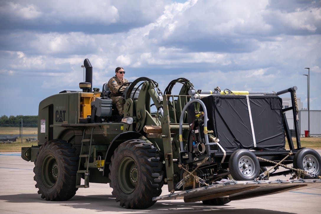 A soldier moves equipment using a forklift vehicle. A soldier moves equipment using a forklift vehicle.