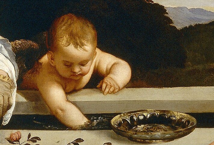 Close view of the winged Cupid leaning over the fountain, his arm in the water.