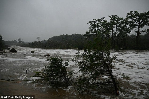 Trees lean as rushing water surges by in Kerrville, Texas, on Saturday. Over 150 people were airlifted from danger during the extensive search and rescue efforts by Texas authorities throughout Friday