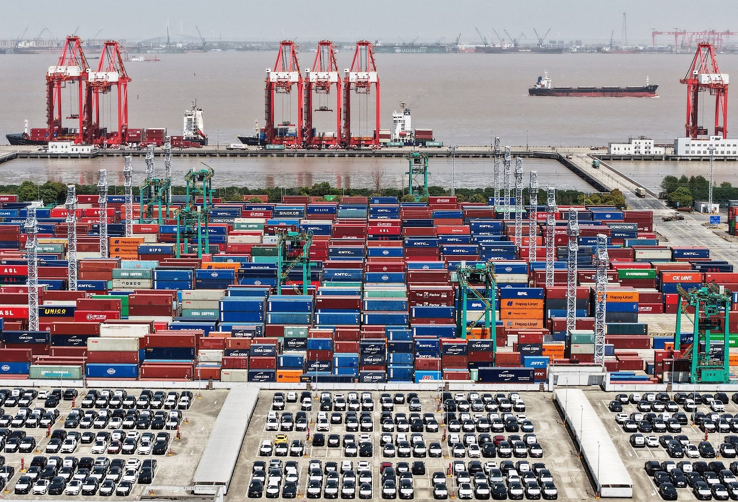 Drone view shows electric vehicles (EV) for export and containers sitting at a port in Shanghai Drone view shows electric vehicles (EV) for export and containers sitting at a port in Shanghai