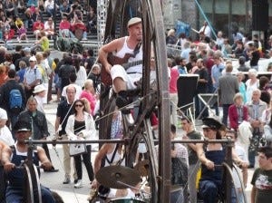 A man playing an instrument on a large wheel