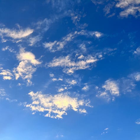 Sunset, clouds and blue sky, and Zia sun symbol