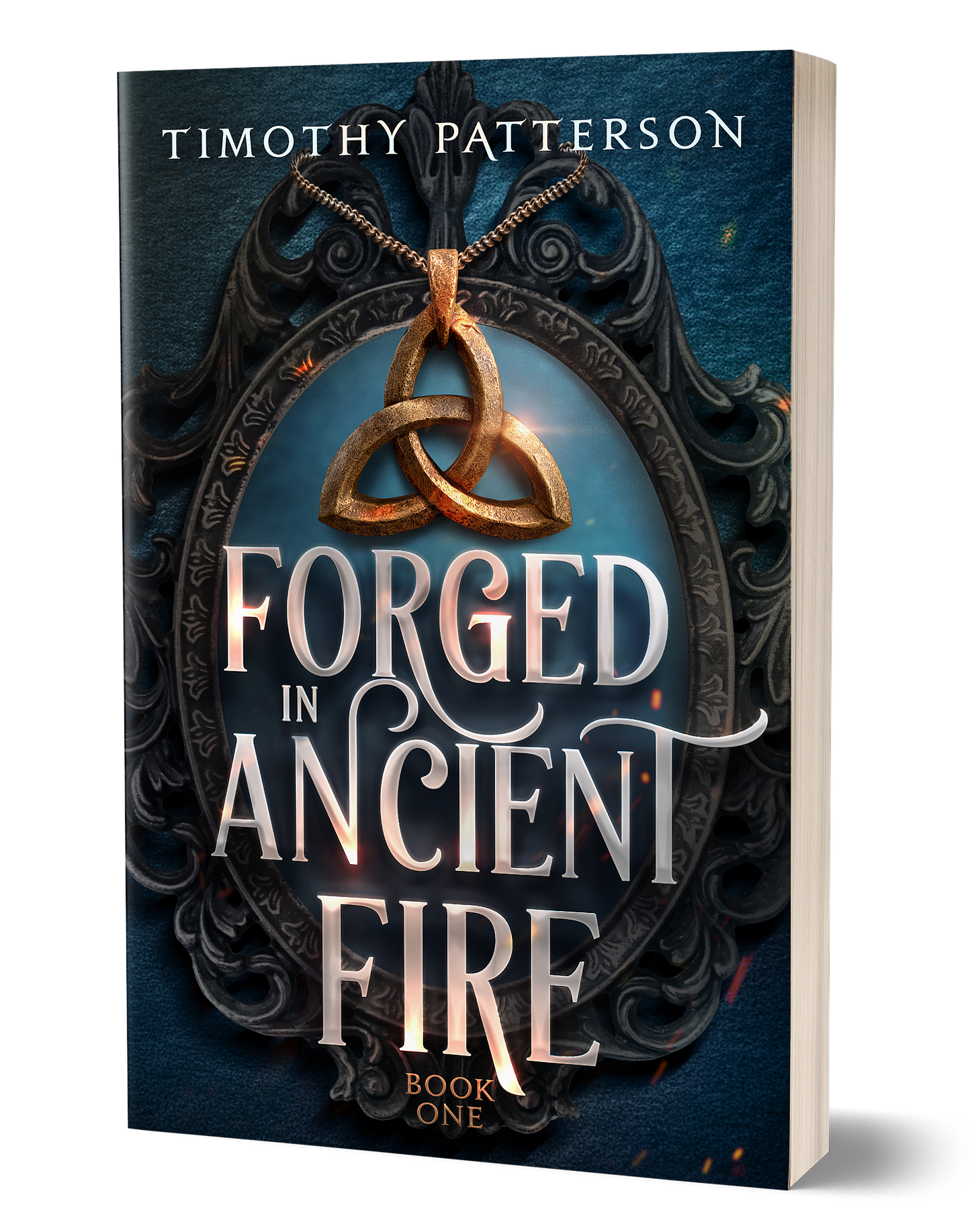 3D paperback mockup of Forged in Ancient Fire by Timothy Patterson. The cover features a gold triquetra amulet suspended before an ornate black mirror, with glowing embers and blue tones creating a magical atmosphere. Large silver-white lettering displays the title, and the cover is marked as Book One in the series.