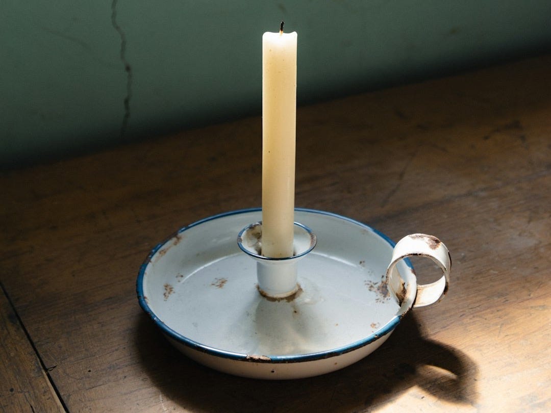 a white candle sitting on top of a wooden table