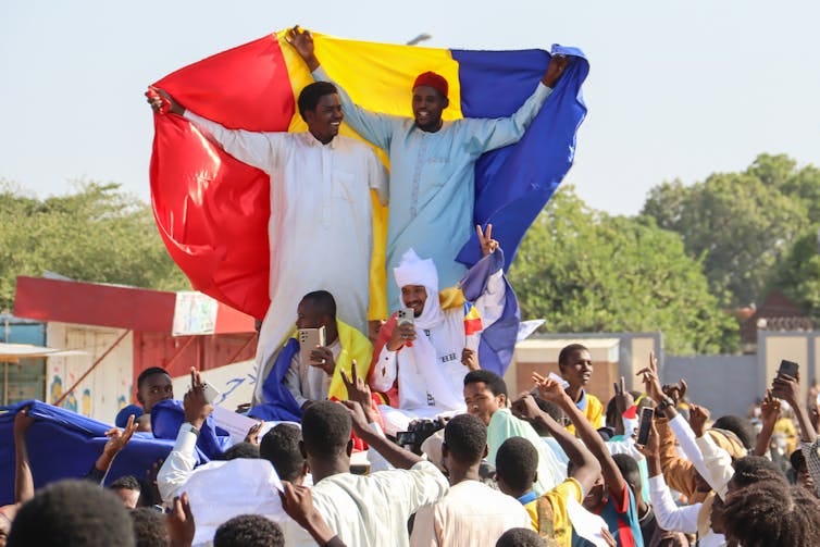 A crowd of Chadians holding flags as they protest. A crowd of Chadians holding flags as they protest.