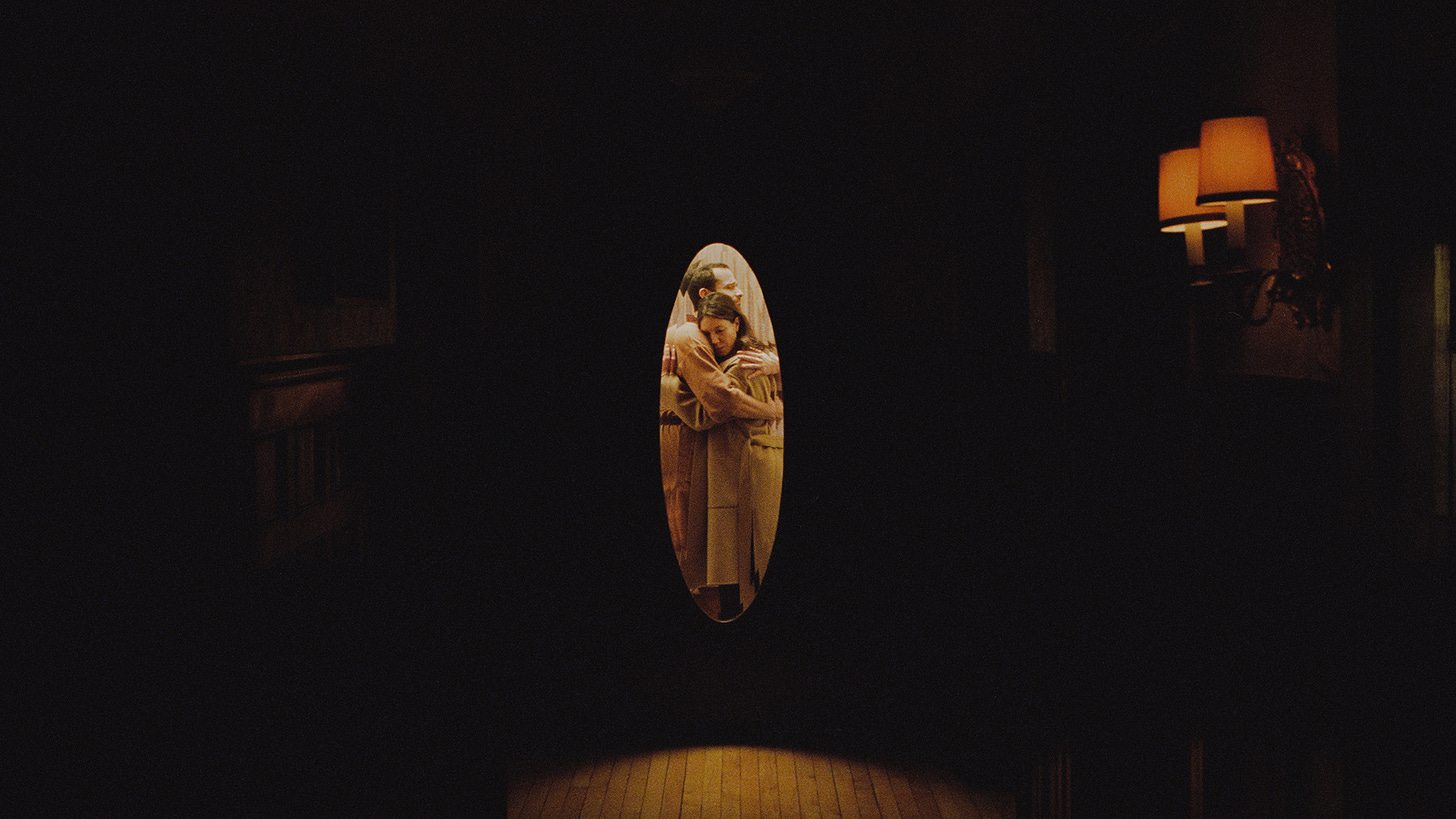 Two people hugging in the light of a hallway.