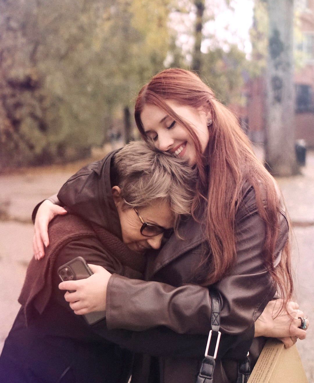 two women hugging each other on a city street two women hugging each other on a city street