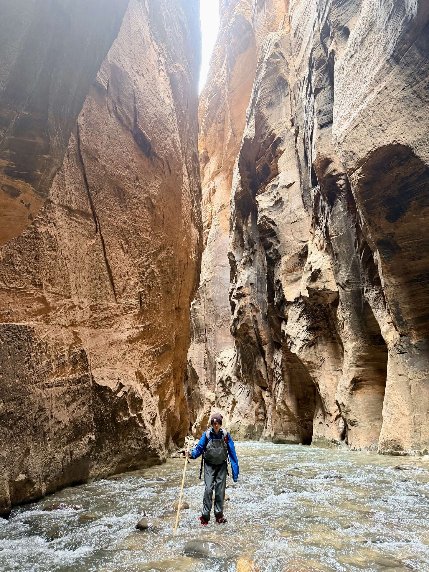 Hiking through the Narrows in Zion National Park with towering canyon walls