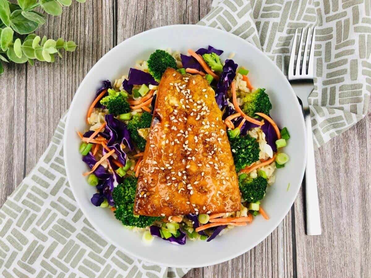 Teriyaki Salmon Bowl with salmon and viggies in a while bowl.