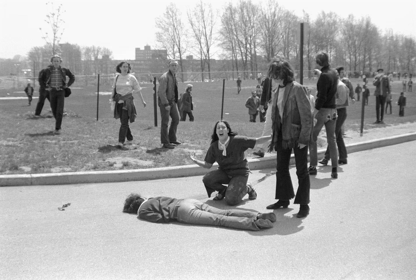 A group of people standing around a person lying on the ground
AI-generated content may be incorrect.