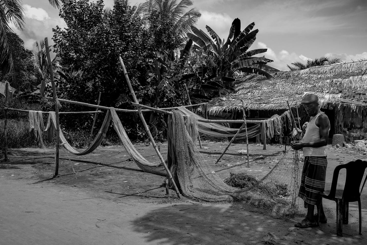 A person mending fishing nets by hand, representing the careful craft of repair and maintenance A person mending fishing nets by hand, representing the careful craft of repair and maintenance