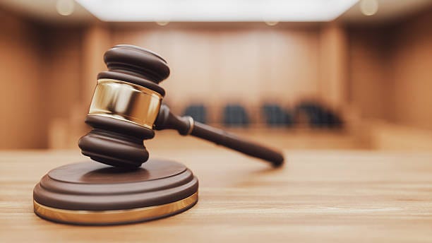 Gavel on a Courtroom Desk A wooden judge's gavel and sounding block on a desk with a blurred courtroom in the background. Focus on themes of law, authority, and verdicts. 3D rendering. court stock pictures, royalty-free photos & images