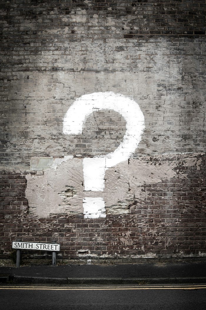 big question mark written on wall big question mark written on wall