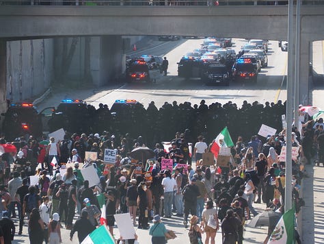 Protesters and California Highway Patrol officers facing each other on the 101 freeway in Los Angeles.