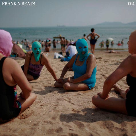 Women, wearing nylon masks, chat as they rest on the shore during their visit to a beach in Qingdao
