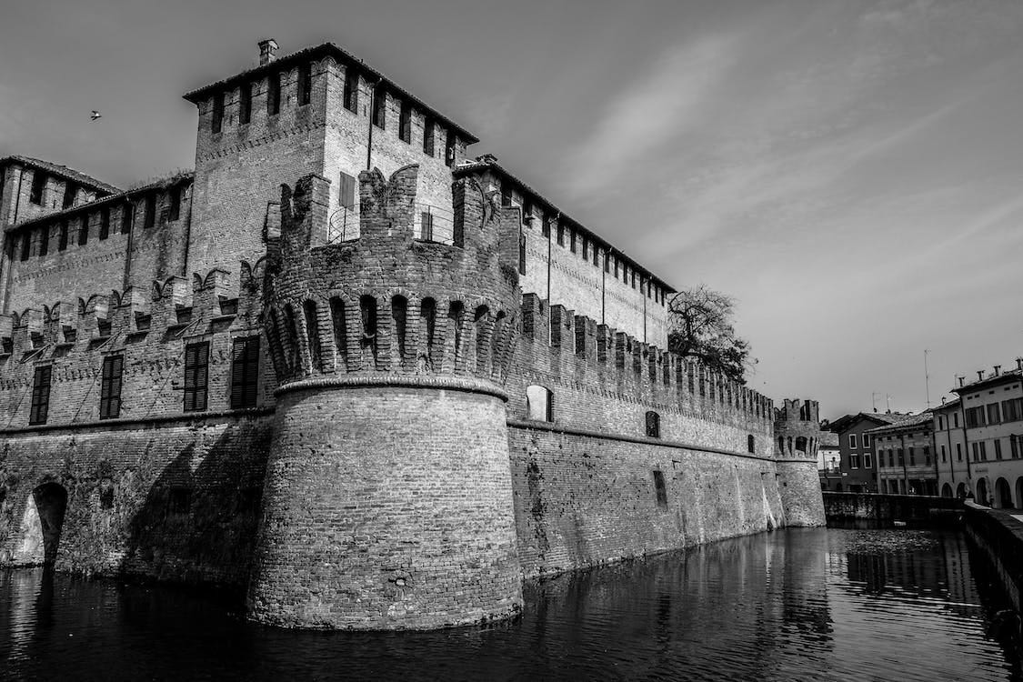 Kostenlos Graustufenfotografie Des Schlosses Nahe Dem Gewässer Stock-Foto