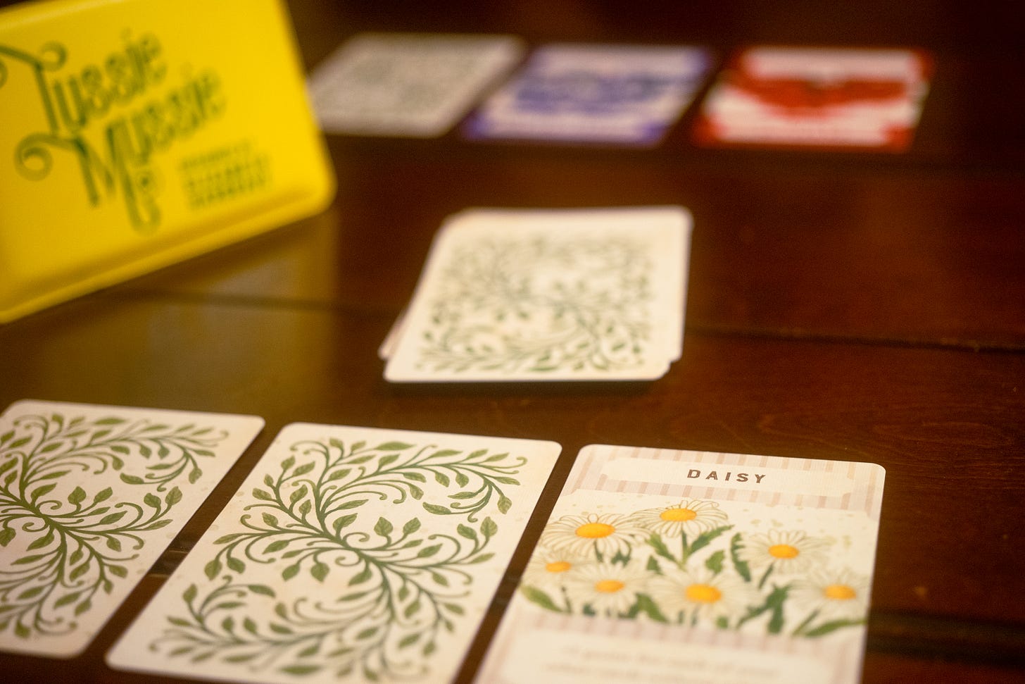 Cards from the small card game Tussie Mussie. A card titled Daisy is visible. The others are turned upside down.